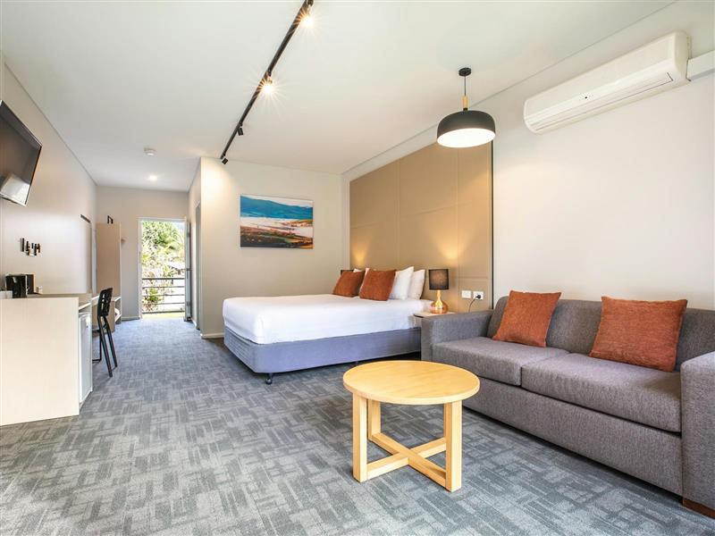 Studio Queen room sofa in the foreground and bed in the bakground