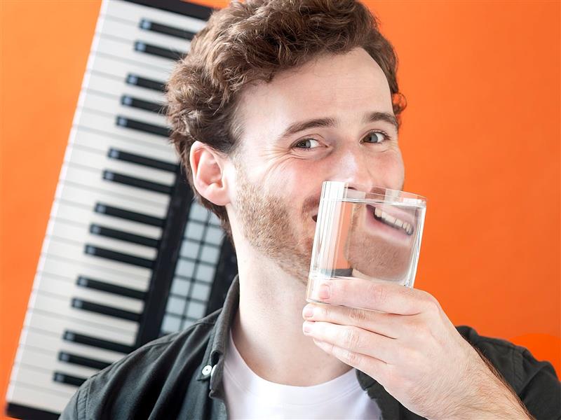 Artist Doug Rintoul posing in front of a keyboard, smiling