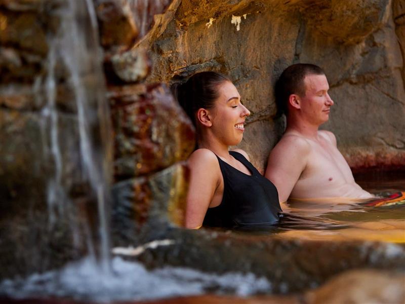 Relaxed couple bathing in Hot Springs rock pool