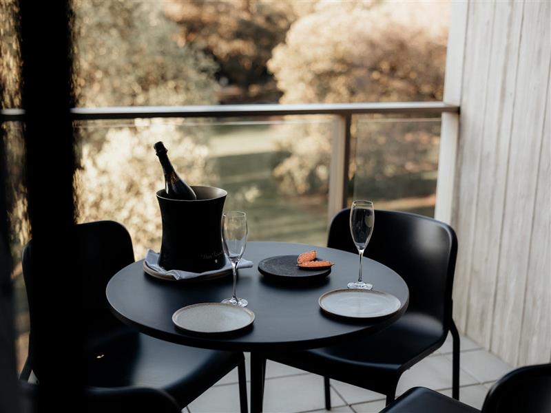 Outdoor dining table on terrace with Dom Perignon bottle, glasses and snack