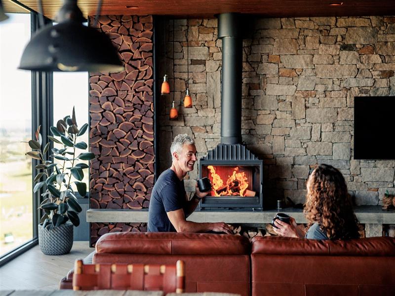 Romantic couple sitting in front of the fireplace at BullerRoo