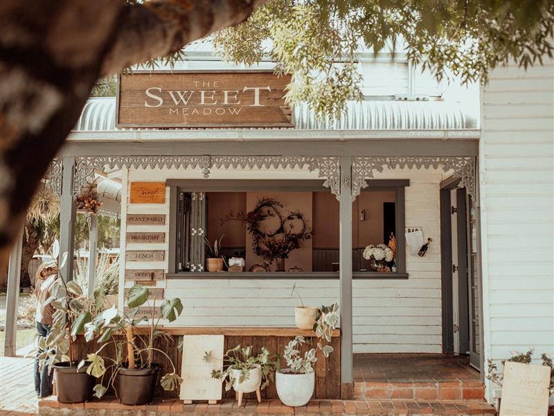 A photo of our cottage with plants lining the outside.