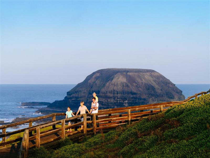 A family walking along Nobbies boardwalk, Phillip Island, Victoria. 
